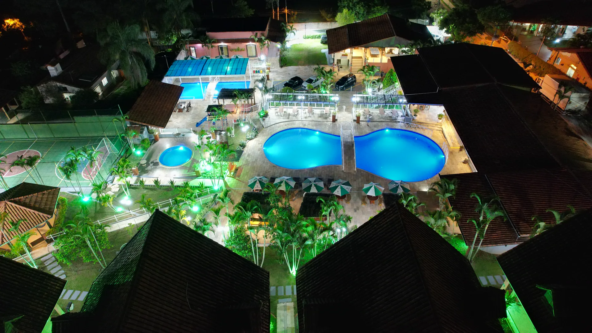Vista aérea noturna do Hotel Gran Minas com as piscinas iluminadas