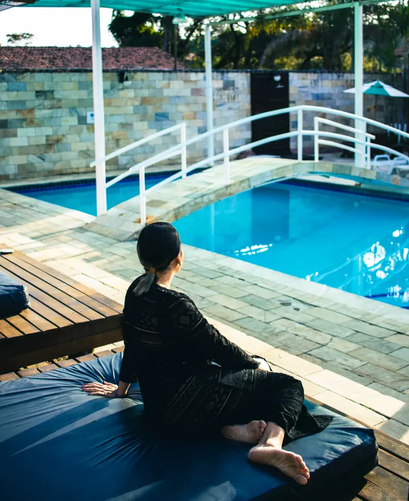 Hóspede relaxando no deck da piscina climatizada do Hotel Gran Minas